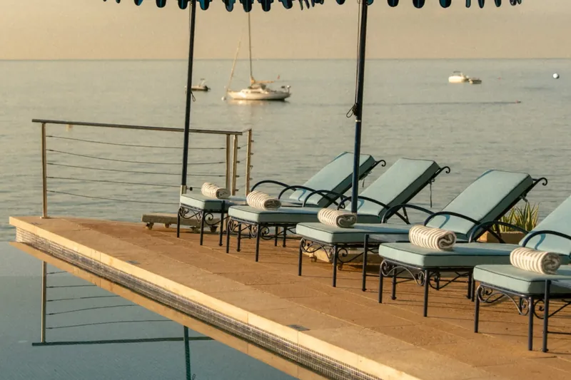 Gran Hotel Maricel de Hospes: piscina frente al mar con sombrillas azules y tumbonas al atardecer