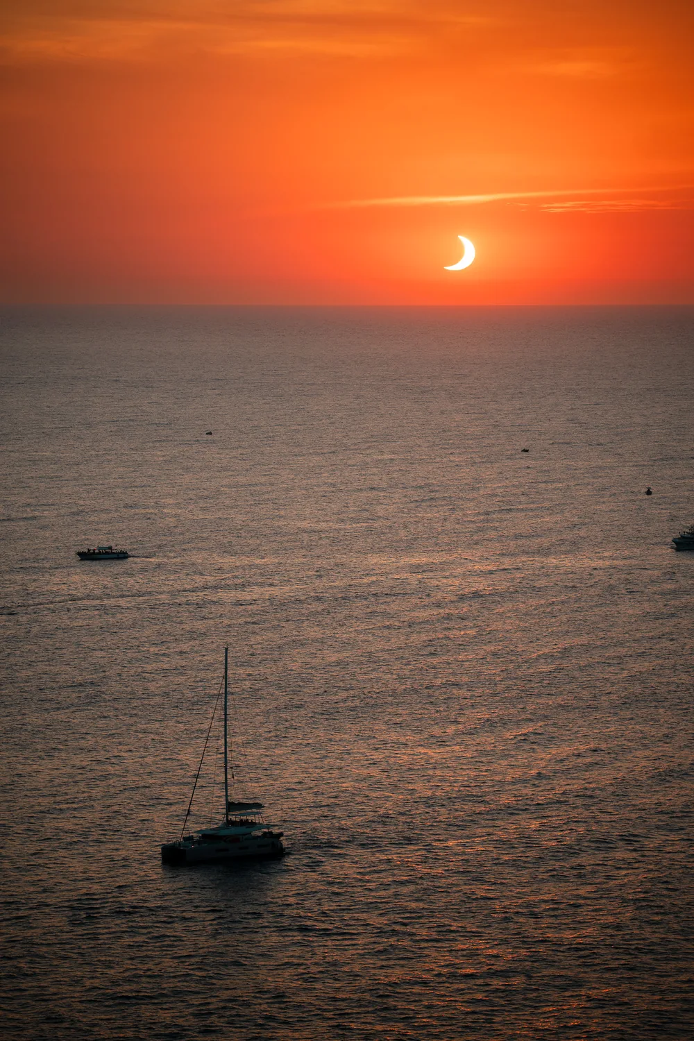 Eclipse sobre el Mediterráneo con un catamarán frente a la costa, visto desde Jumeirah Mallorca