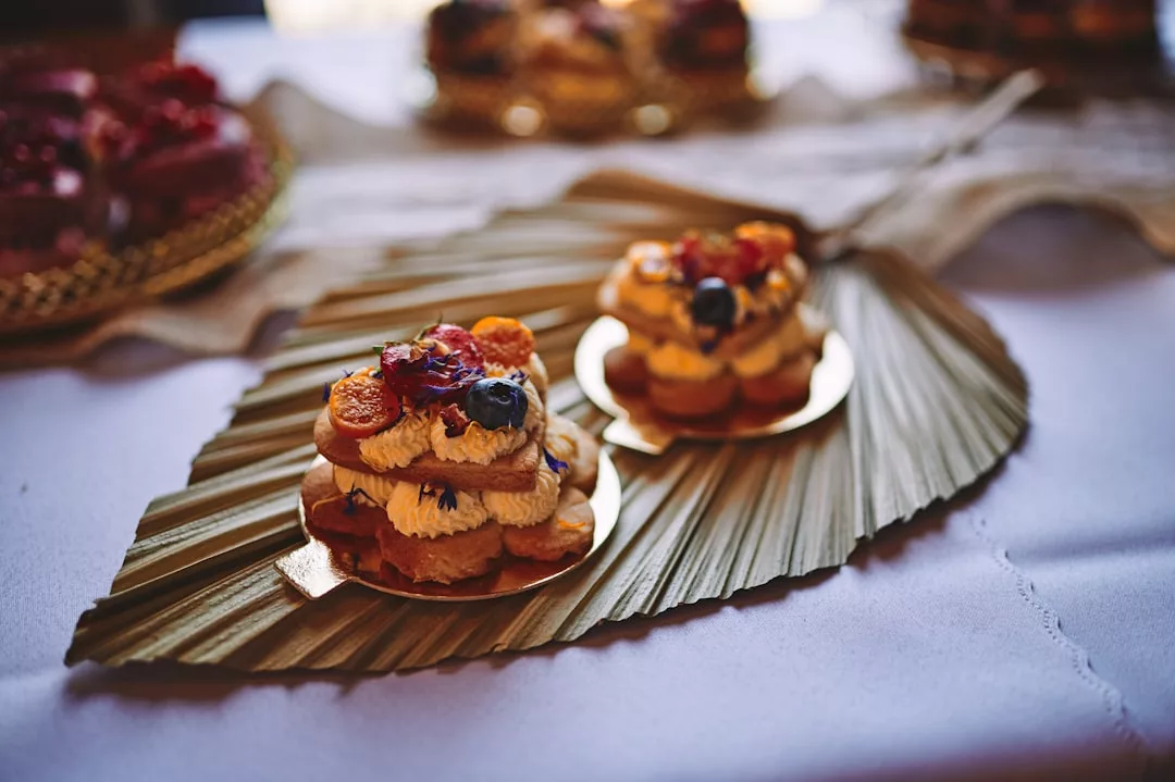 Sobre un mantel blanco se colocan dos pequeñas capas de bollería cubiertas de nata, bayas y frutos secos sobre una decorativa hoja de palmera seca, captando así la esencia del relajado lujo mallorquín.