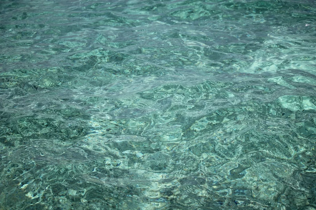 Aguas turquesas, claras y poco profundas, con ondulaciones visibles y la luz del sol reflejándose en la superficie, crean una escena de puro lujo en las costas de Mallorca.