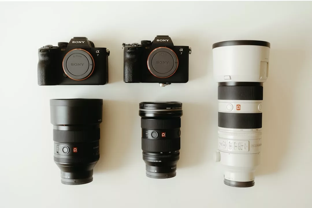 Dos cámaras Sony Alpha y tres objetivos Sony, incluido un gran teleobjetivo, están dispuestos sobre una superficie blanca en dos filas, listos para capturar el lujo de los impresionantes paisajes de Mallorca.