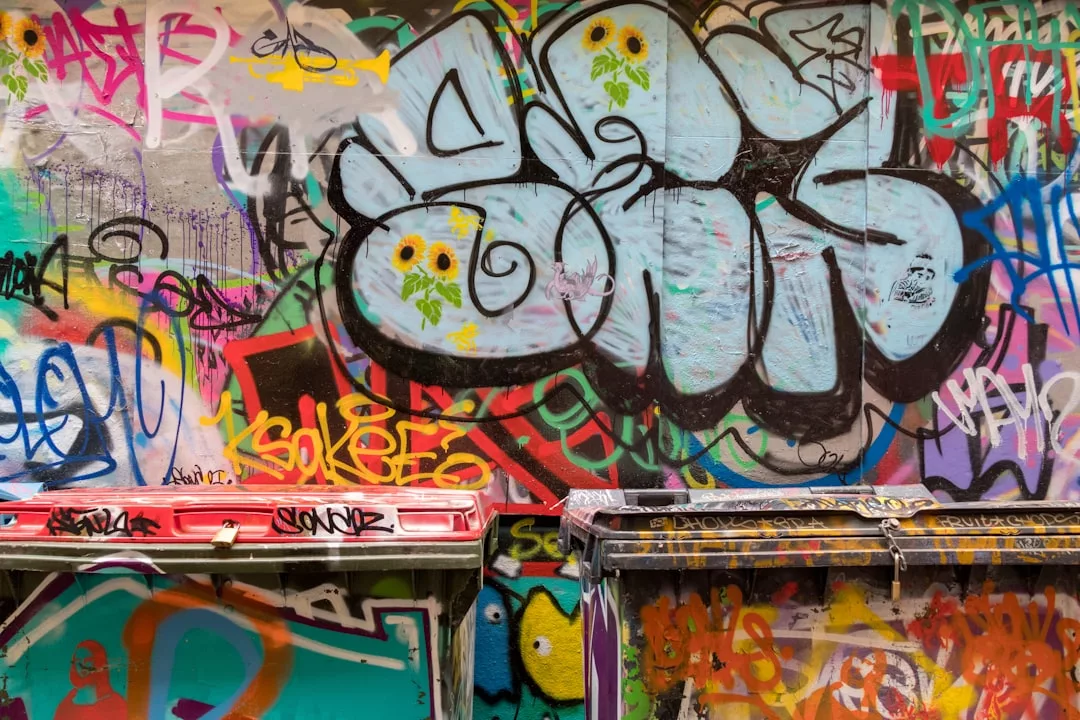 Dos grandes cubos de basura frente a un muro cubierto de grafitis de colores y etiquetas pintadas con espray aportan un toque de arte urbano a las calles de Mallorca, donde incluso las escenas cotidianas tienen un toque de lujo.