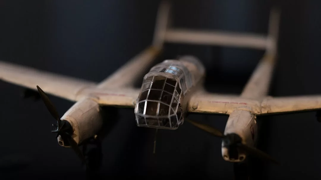 Primer plano de una maqueta de avión con dos hélices y una cabina despejada, que evoca el lujo de la aviación clásica, fotografiada sobre un fondo oscuro que recuerda los vuelos sobre la pintoresca costa de Mallorca.